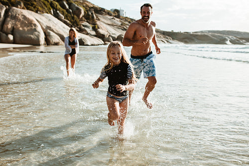 Family running in water at the beach