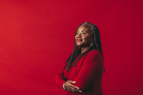 Pensive woman with dreadlocks standing in a studio