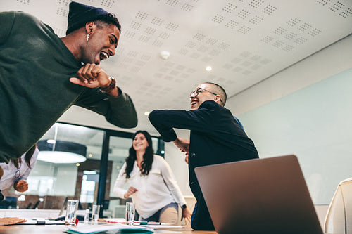 Bubbly businesspeople elbow bumping each other before a meeting