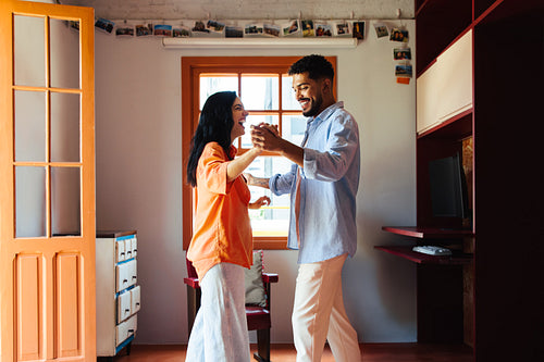 Couple dancing together in a cozy and bright living room setting