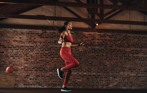 Healthy woman skipping rope at gym