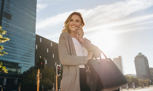 Businesswoman making a call while walking in the city