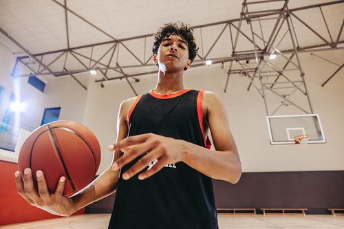 Teen basketball player practicing indoors