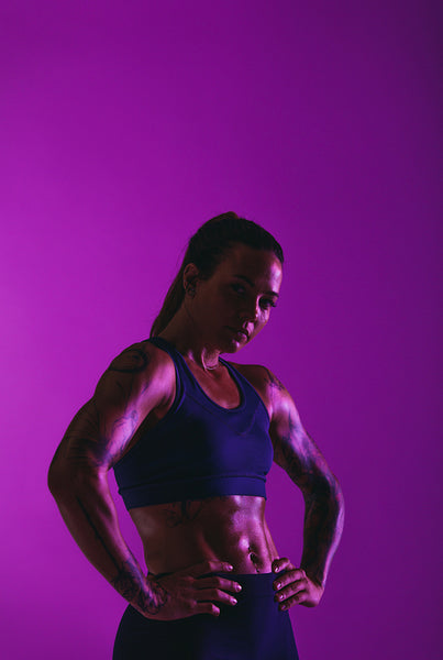 Portrait of fit woman on purple background