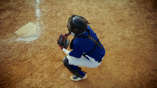 Catcher prepares behind home plate on the field