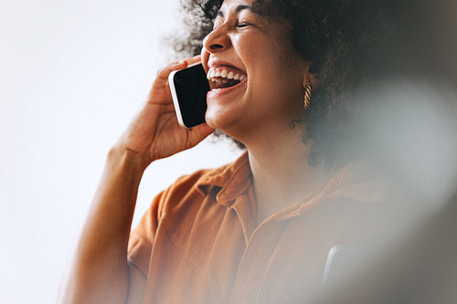 Businesswoman laughing happily on a phone call