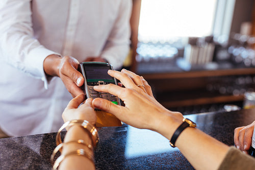 Woman paying by credit card at cafe