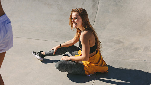 Smiling young woman sitting on ground