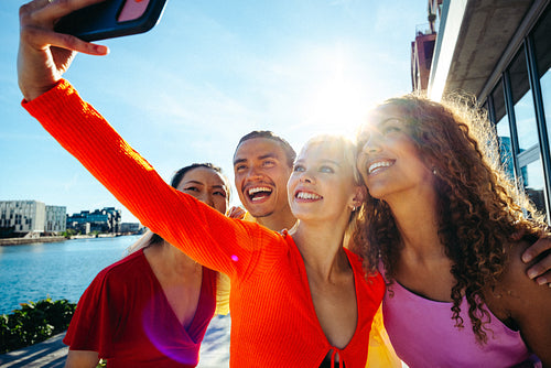 Friends take a selfie together outdoors by the urban waterfront