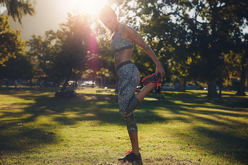 Healthy young woman stretching in a park