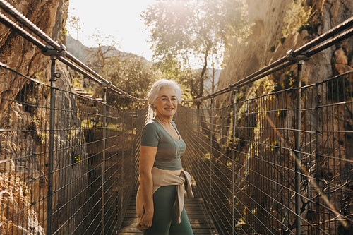 Happy senior woman going hiking outdoors