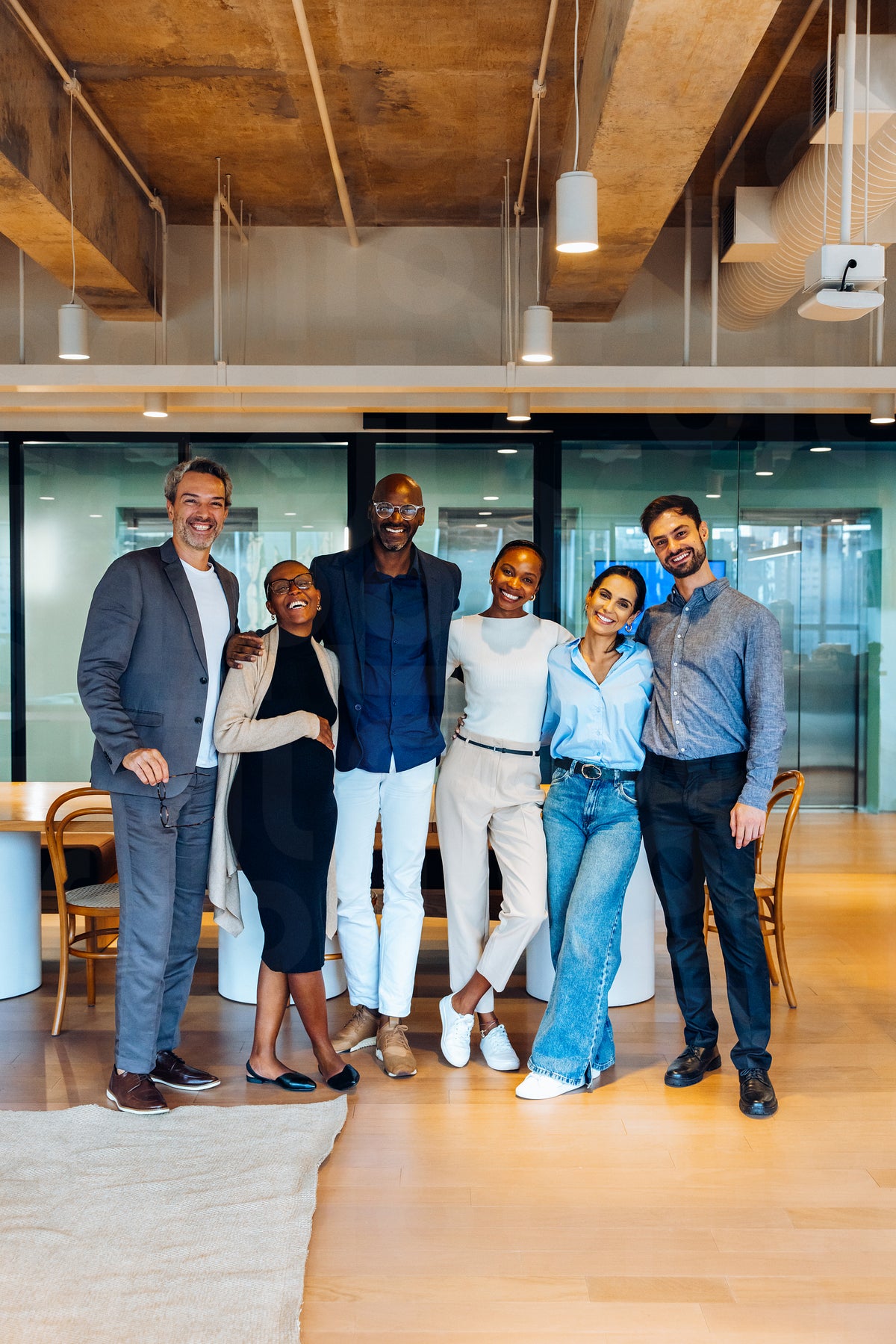 Group of diverse coworkers smiling together in a stylish open office s ...