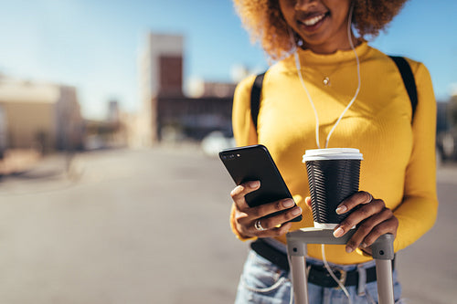 Tourist woman walking on street looking at mobile phone