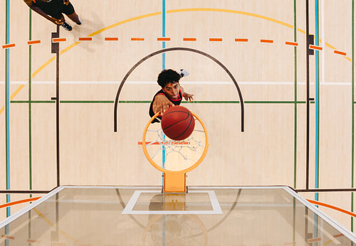 Top view of a basketball player making a shot on an indoor court