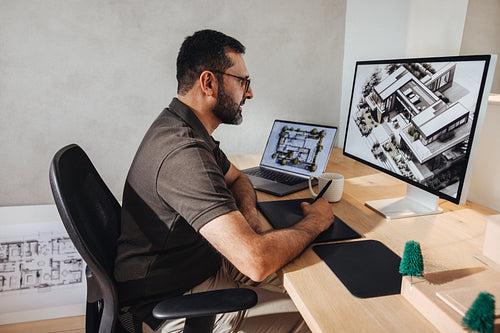 Architect designing modern homes using computer in a professional workspace