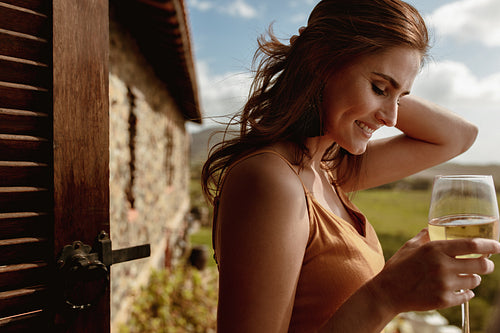 Woman enjoying a glass of wine standing outdoors