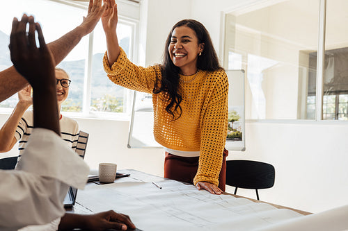 Young woman leading a team discussion at an architecture firm meeting