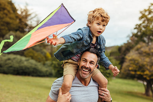 Happy father and son flying kite outdoors