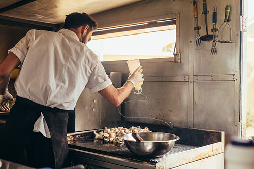 Male cook preparing food on truck
