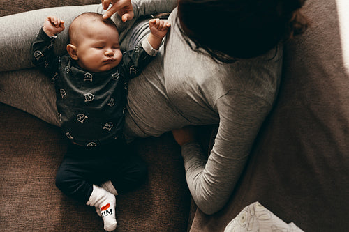 Top view of a baby sleeping in the lap of his mother