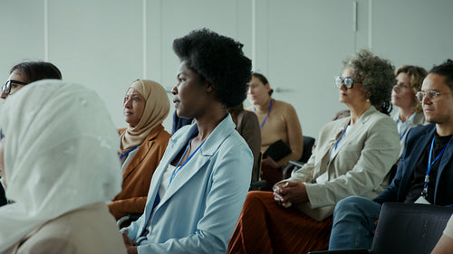 Business people attentively listening at a conference, representing global engagement