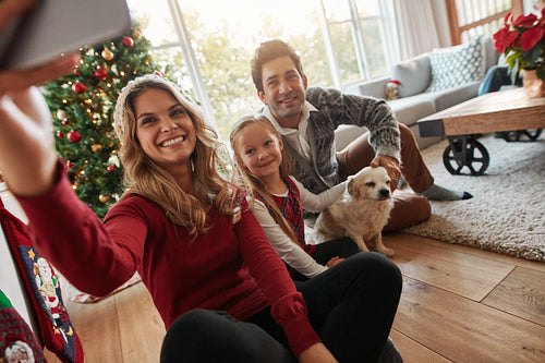 Young happy family taking selfie on Christmas eve