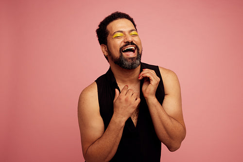 Genderqueer with makeup on pink background