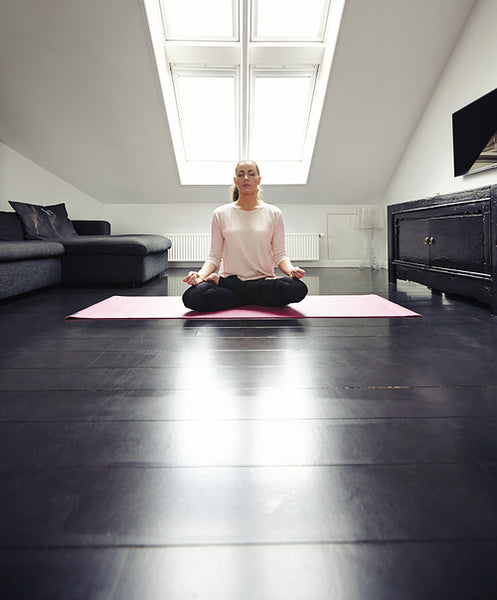 Young lady practicing yoga in her living room