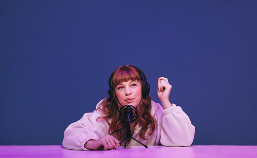 Woman with ginger hair whispering into a microphone while recording an asmr show