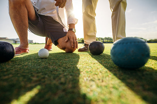 Close up of men watching the boules on the ground