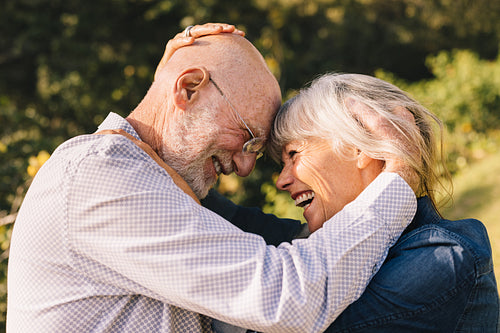 Affectionate senior couple touching their heads together outdoor