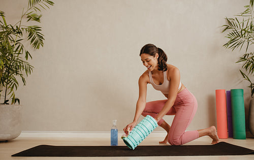 Woman disinfecting exercise roller in fitness studio