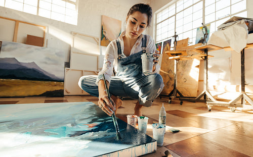 Female artist painting on a canvas in her studio