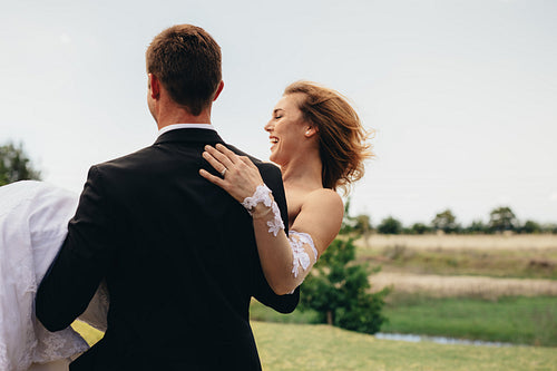 Bridegroom carrying bride on wedding day