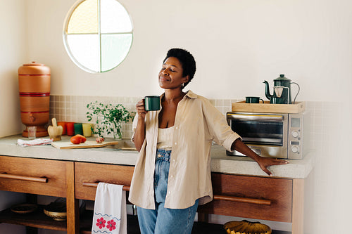 Brazilian woman enjoying coffee and a relaxing moment in the kitchen