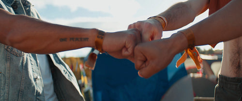Close up fist bump of friends at festival having fun