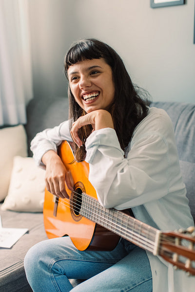 Smiling female musician holding a guitar
