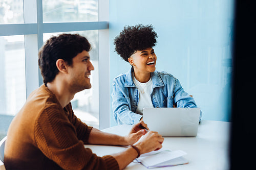 Colleagues share a laugh in a modern office
