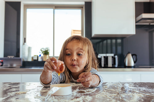 Beautiful young girl baking in the kitchen