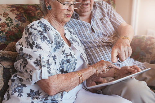 Retired couple at home using touch screen computer