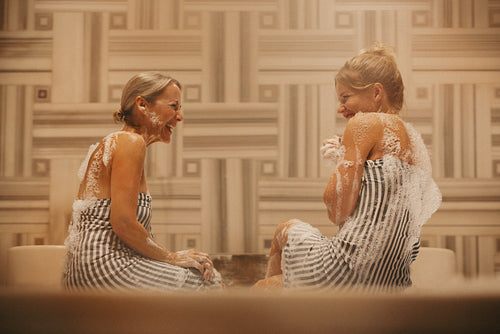 Two women enjoying a fun and relaxing hammam wellness experience together
