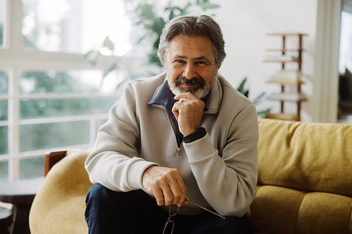 Senior man relaxes at home on a sofa