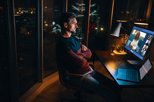 Business man having a late night online meeting with his team on his computer
