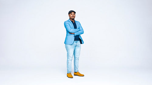 Businessman in cap standing with his arms crossed