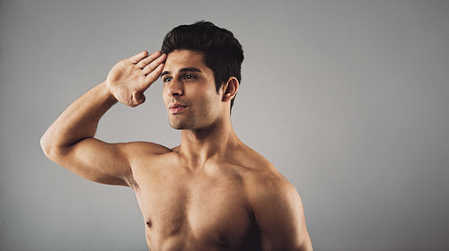 Young muscular man saluting