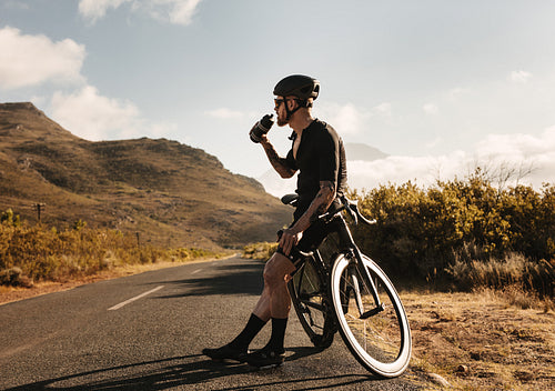 Cyclist taking rest and drinking water 