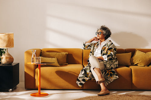 Pensive businesswoman sitting on a couch in an office lobby