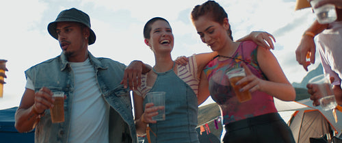 Happy young friends embrace at a music festival