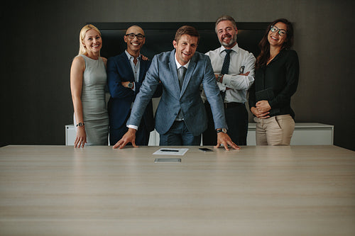 Smiling group of business professionals in meeting room