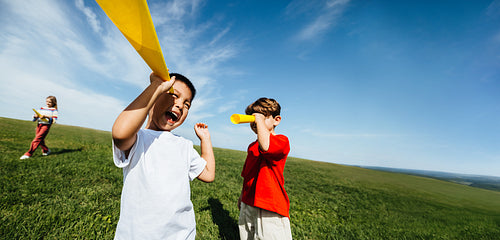 Kids pretending to explore with playful telescopes outdoors